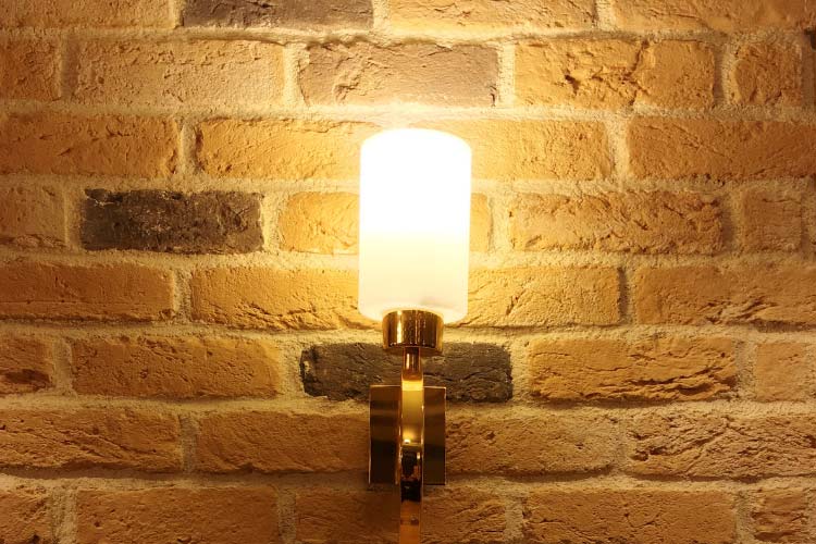 Position solar wall sconces with motion sensors evenly along exterior walls for extra security