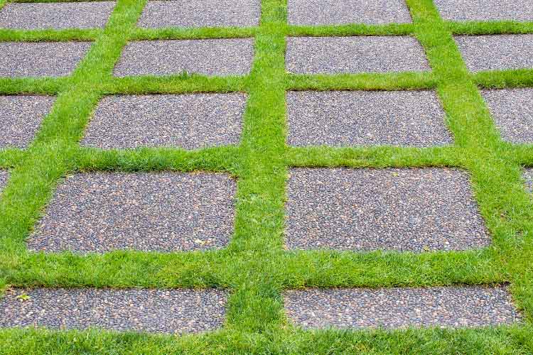 Alternate your pavers with narrow strips or bands of grass to reduce the number of pavers needed