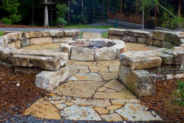 The beauty of rustic flagstone is that it makes your fire pit feel carved from the landscape rather than placed on it