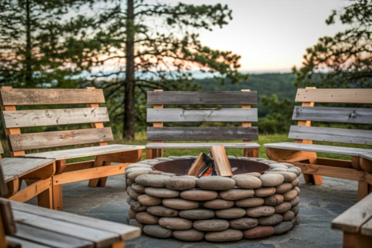 A stunning lake and a cozy fire pit made of natural stone simply go together