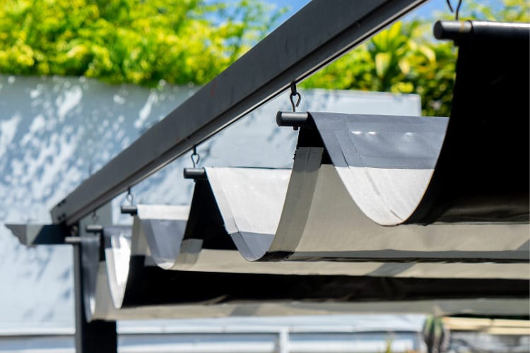 Layer your pergola with an extra sail to soften the rigid lines and to provide even more shade