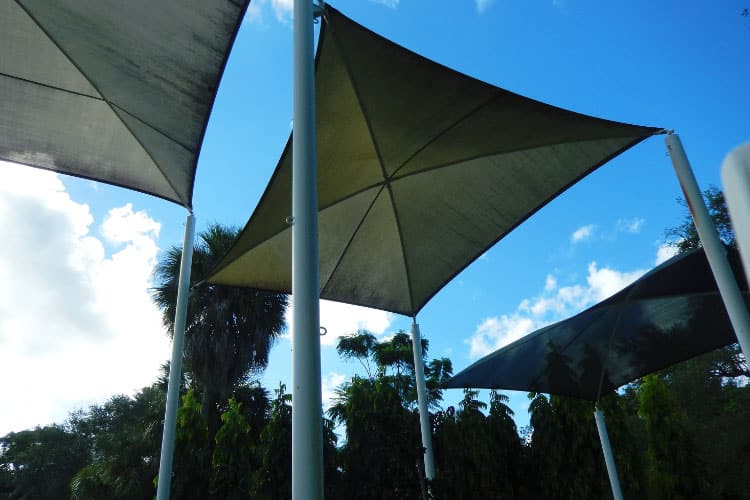 Metal posts embedded in concrete footings or attached to patio decking provide strength and stability