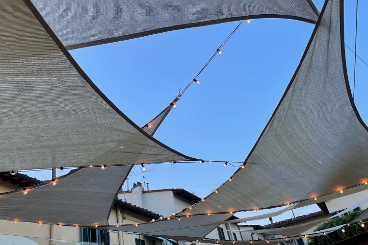 Attach them along the edges of the sail or drape them underneath to create a glowing canopy that makes your shaded patio usable at night
