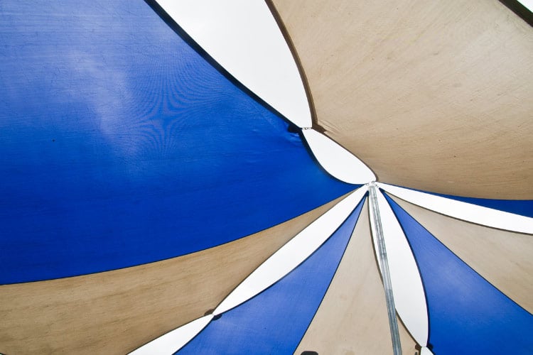 Shade sails can cover broader areas than outdoor curtains